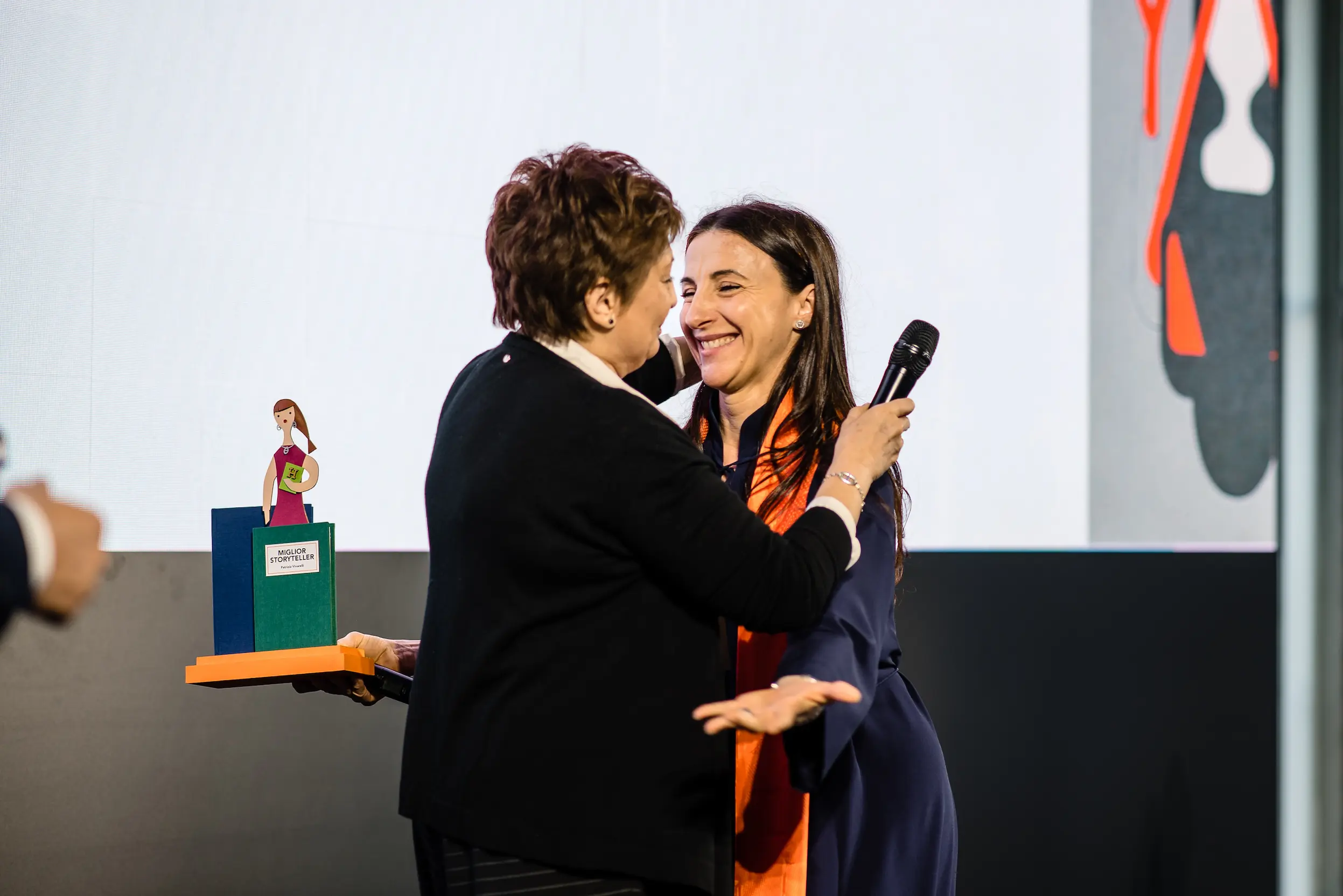 Due partecipanti all'Hermes Day che si abbracciano