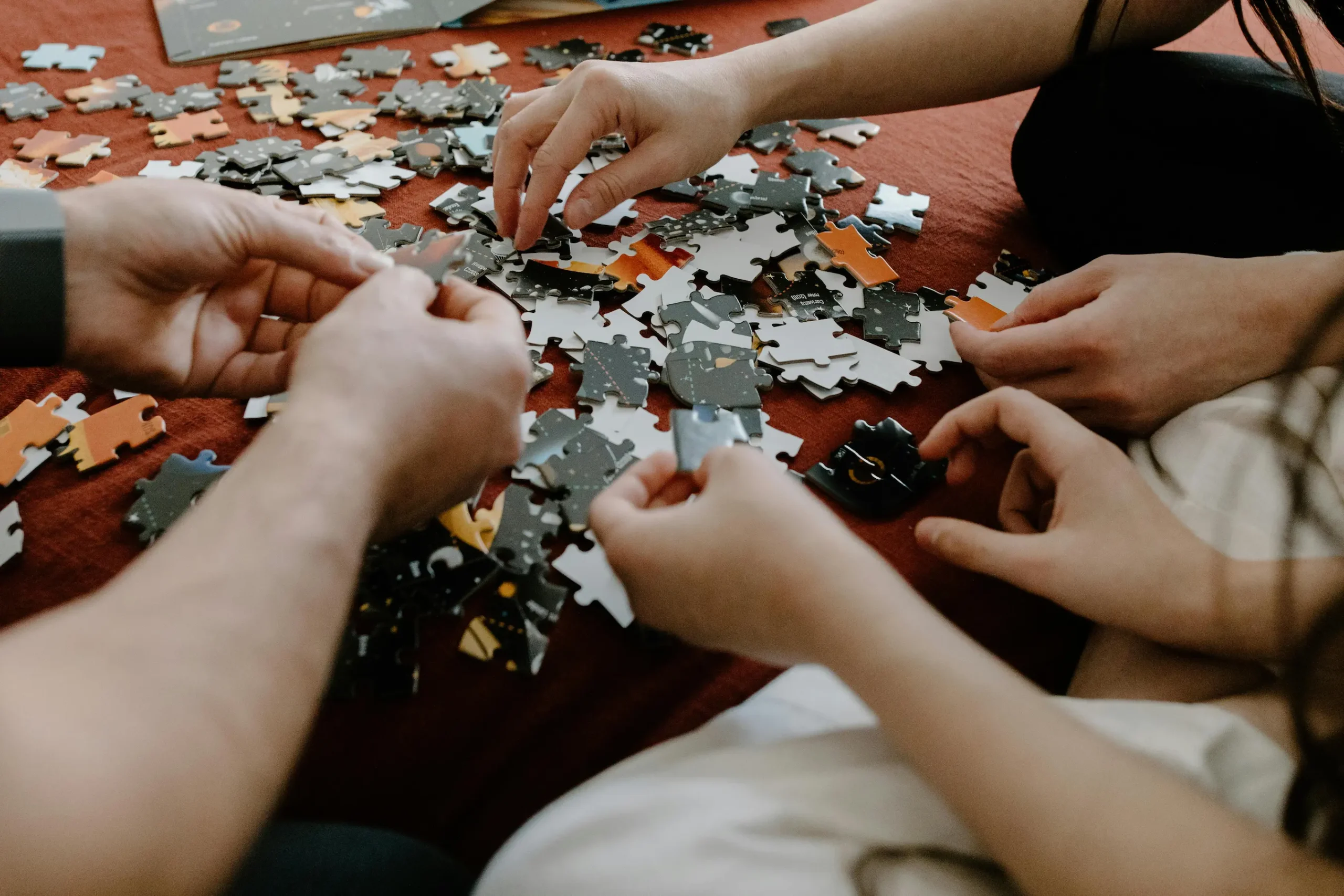 persone che collaborano per costruire un puzzle