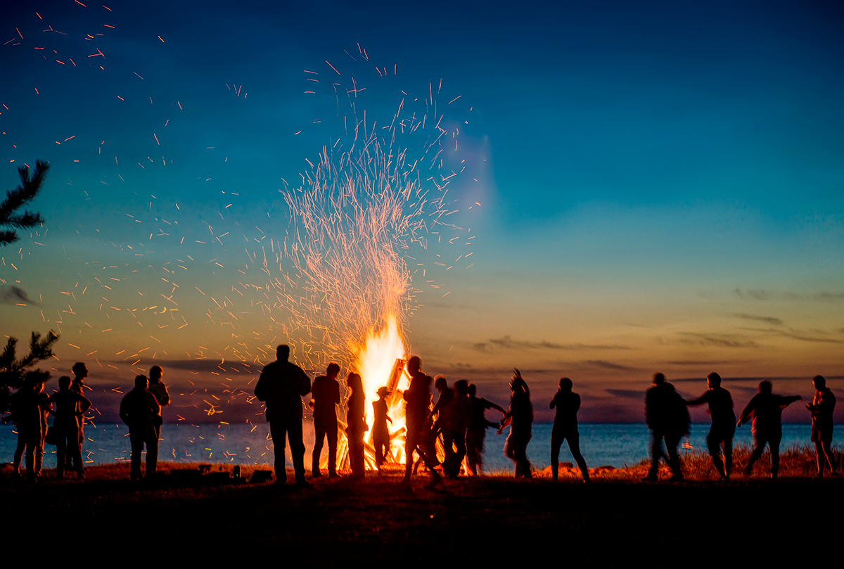 Falo in spiaggia di persone alla sera